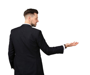 Young businessman holding something on gray background