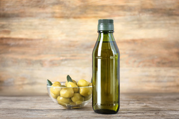 Composition with olive oil in bottle on wooden background