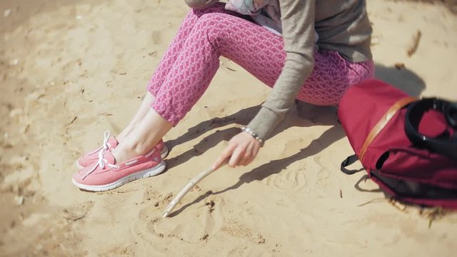 A woman listens to music on headphones, relaxes and dances on the shore of the sea river of the ocean. Technology in the open air