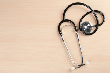 Stethoscope on light wooden background