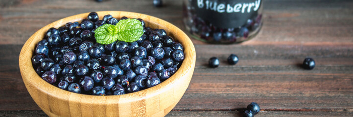 blueberries in a bowl on a wooden table.