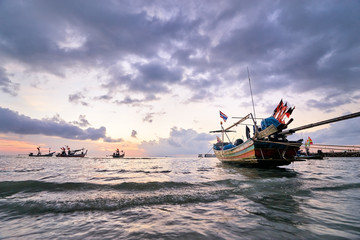 Obraz premium Beautiful sunset on the sea with traditional thai longtail boats.