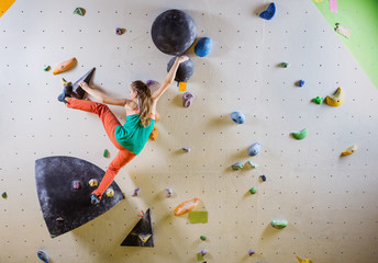 Young woman climbing bouldering route - obrazy, fototapety, plakaty
