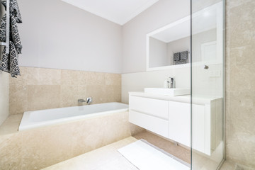 Fototapeta na wymiar Modern bathroom interior with bathtub and light coloured decor.