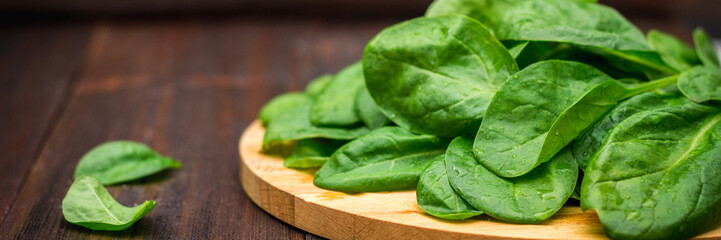 Fresh juicy spinach leaves on a wooden brown table. Natural products, greens, healthy food,...