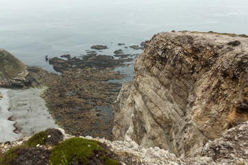 Summer Atlantic rocky coast view Big stony rockfall on precipice shore and ocean surf waves. Crozon, France View near the Memorial naval aviation Cape of the Goat May 2018