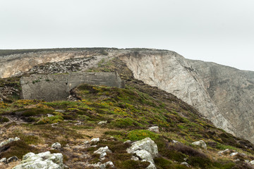 Summer Atlantic rocky coast view Big stony rockfall on precipice shore and ocean surf waves. Crozon, France View near the Memorial naval aviation Cape of the Goat May 2018