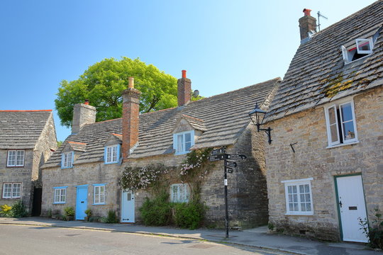 A row of medieval houses with brickstone and flagstone roofs in Corfe castle village, Isle of Purbeck, Dorset, UK