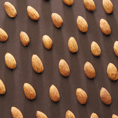 Fresh almonds on a brown paper background. Pattern of nuts