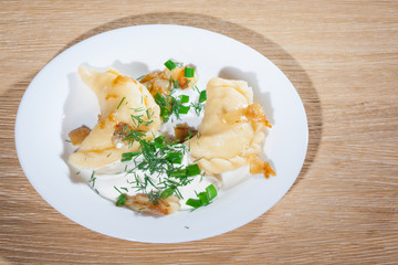 Ukrainian vareniki served on the Faror plate with onions, sour cream and dill