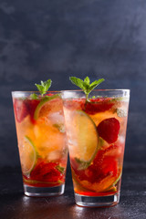 Strawberry mojito cocktail with berries, lime, mint and ice. Summer berry cocktail