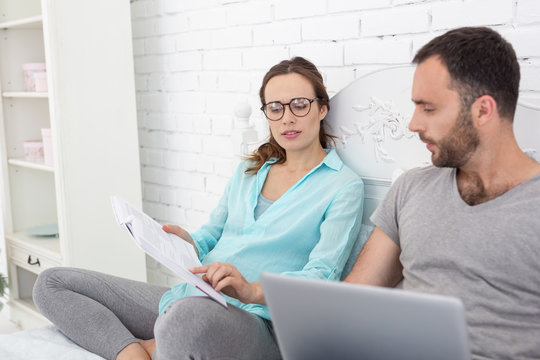 Facts about baby. Appealing pregnant woman and man staring at book and communicating