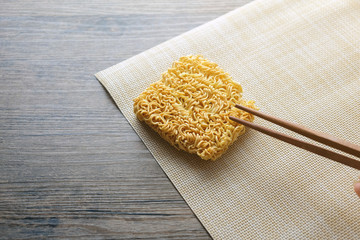 chopsticks and instant noodle on the wooden table.