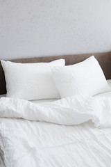 Fototapeta na wymiar Cozy bed with crumpled white linen