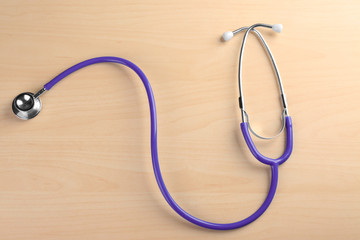 Stethoscope on light wooden background
