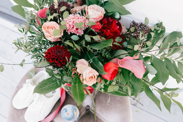 Wedding flowers, white sneakers and accessories, bridal bouquet closeup. Decoration made of roses, peonies and decorative plants