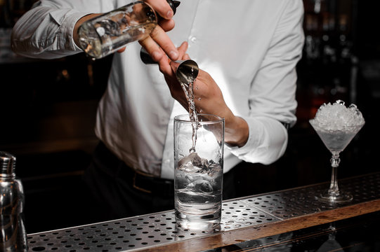 Bartender adding an alcoholic drink into the glass