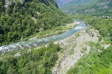 Fototapeta na wymiar Alpine river seen from above. In summer the river gets thicker due to the thaw of the glaciers. Top view of the river Sesia in Piedmont, Italy.