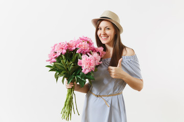 Young tender woman in blue dress, hat holding bouquet of beautiful pink peonies flowers, showing thumbs up isolated on white background. St. Valentine's Day, International Women's Day holiday concept.