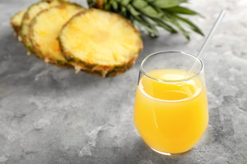 Glass of sweet pineapple juice on table
