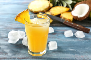 Glass of sweet pineapple juice on wooden table