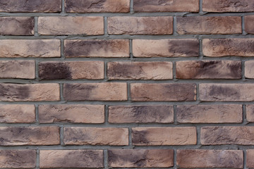 Obraz premium Brick wall with spotted brown bricks. Used as a background.