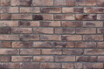 Brick wall with variegated brown bricks. Used as a background.