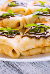 Pancakes with chocolate and mint leaves