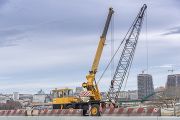 Fototapeta na wymiar Construction crane truck on the bridge in the city with cloudy sky