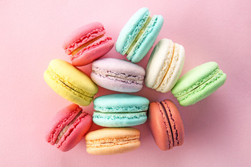 Fototapeta na wymiar Tasty macarons on color background, top view