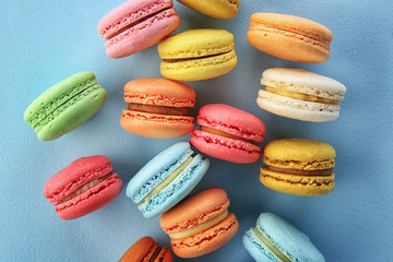 Delicious macarons on color background, top view