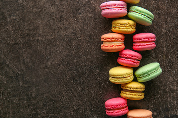Colorful macarons on dark background, top view