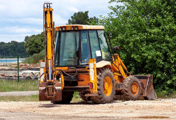 Yellow excavator, bulldozer machine and worker tractor. Road works. Road machinery at construction site. Road company and building machines for construction. Industry, renovation and infrastructure.