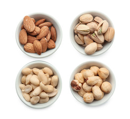 Different nuts in bowls on white background