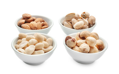 Different nuts in bowls on white background