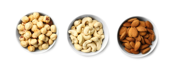 Different nuts in bowls on white background