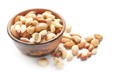 Different nuts in bowl on white background