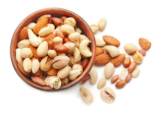 Different nuts in bowl on white background