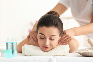 Obraz na płótnie Canvas Happy young woman having massage in spa salon