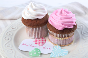 Plate with delicious cupcakes on table. Mother's Day celebration