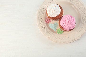 Plate with delicious cupcakes on table. Mother's Day celebration