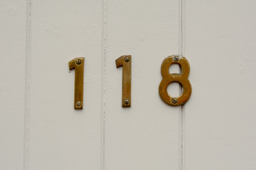 House number 118 sign on wooden door
