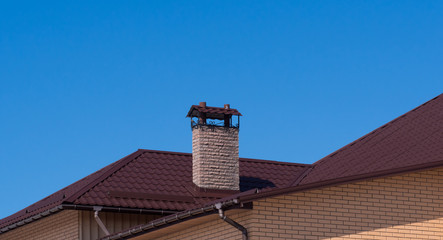 Modern chimney with forging under clear blue sky