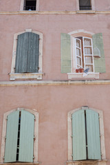 Painted cat and flowers on pastel pink wall with window shutters, Arles, Provence, France.