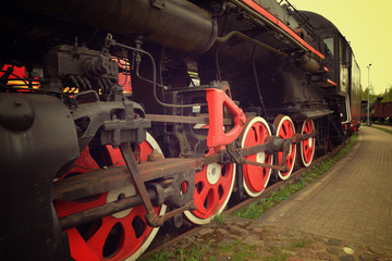 Old black steam locomotive with red wheels