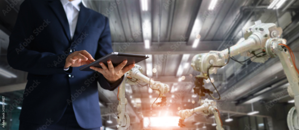 Poster Industrial engineer manager using tablet control automation robot arms machine in intelligent factory industrial. Welding robotic and digital manufacturing operation. Industry 4.0 concept