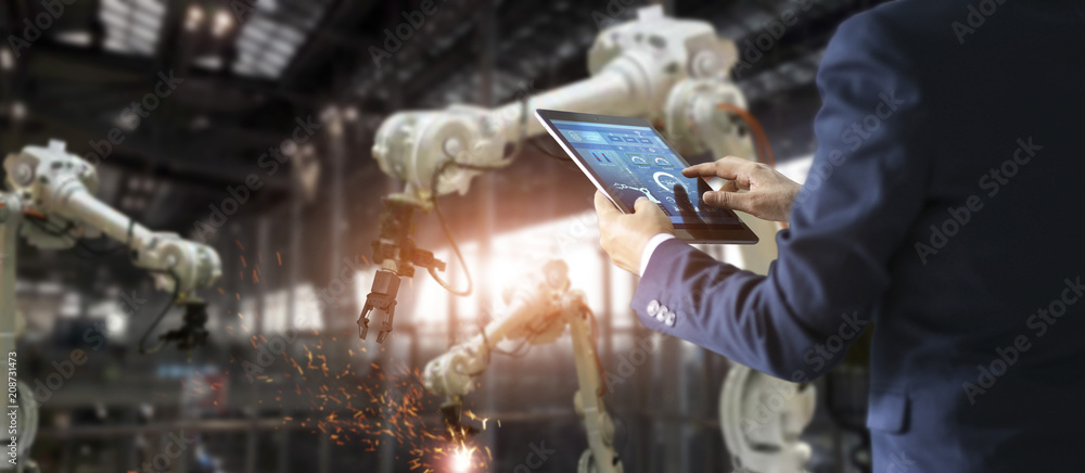 Aufkleber Industrial engineer manager using tablet control automation robot arms machine in intelligent on monitoring. Welding robotics and digital manufacturing operation. Industry 4.0 concept