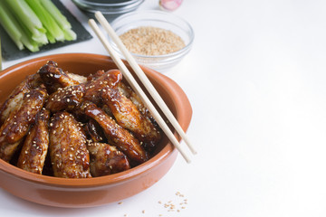 Traditional Asian stir fry chicken wings with sesame and vegetables. Copy space for text