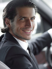 man sitting behind the wheel of a car