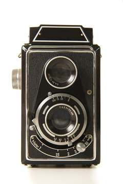 Old antique black photo camera on a white background